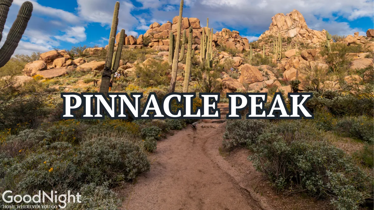 A dramatic exterior shot of Pinnacle Peak's iconic rock formations and rugged cacti-lined trail. The expansive desert landscape stretches toward the horizon, conveying a sense of adventure and tranquility. The image invites viewers to imagine hiking, taking in panoramic views, and enjoying moments of reflection in nature.